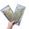 Two packages of dried leaves held by a hand